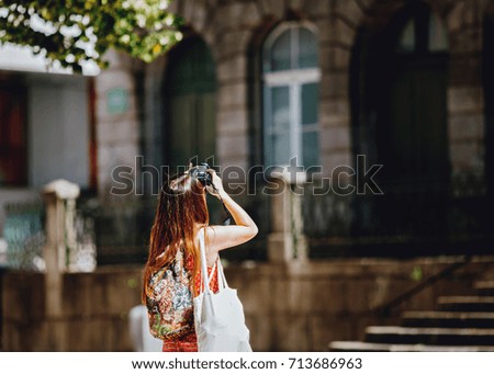 Young girl traveler photographing 