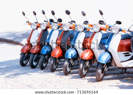 Colorful moped scooter parking. Transport wheel. Summer sunlight flare. Royalty-Free Stock Photo #713696164