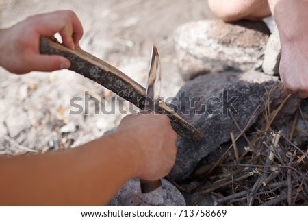 Male camper kindling to start a campfire, bonfire close-up. Man kindles a fire. Fire in nature. Bonfire in the forest.