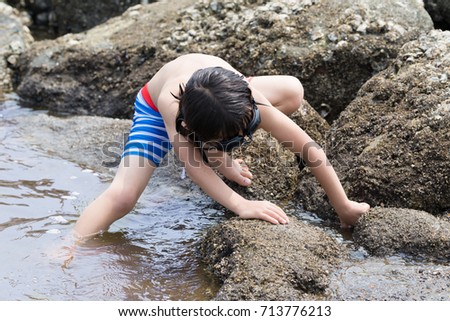 Child playing in the sea, crabs taken