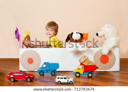  traffic regulation. Creative Little boy plays with his cardboard car. Child having fun at home. Playful childhood. 
