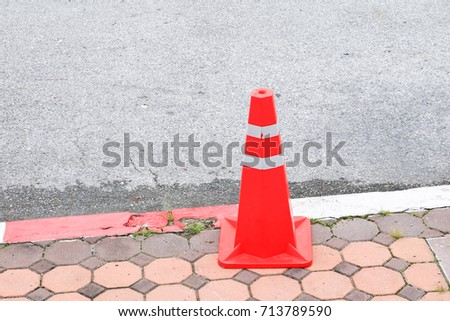 traffic cone orange and swath white stripes on footpath with copy space