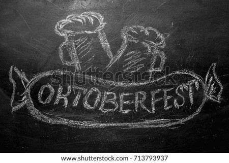 Oktoberfest lettering and a picture of beer with sausage chalk on a blackboard