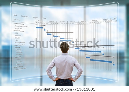 Project manager looking at AR screen with Gantt chart schedule or planning showing tasks and deadlines Royalty-Free Stock Photo #713811001