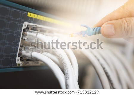 switch and ethernet cables with hand.Data Center Concept.Merge photo.