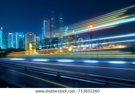 View from Side of flyover,blurred motion effect  with light trails and beautiful city skyline background .