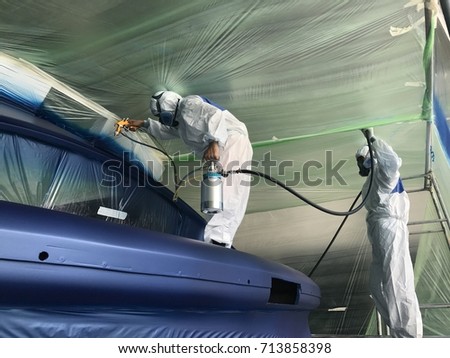 The painter spraying paint to the boat Royalty-Free Stock Photo #713858398