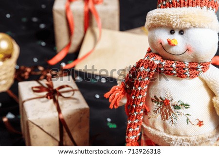 Funny Snowman on the background of Christmas gifts and decorations.