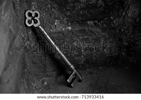 Large old key in hollow of stone wall