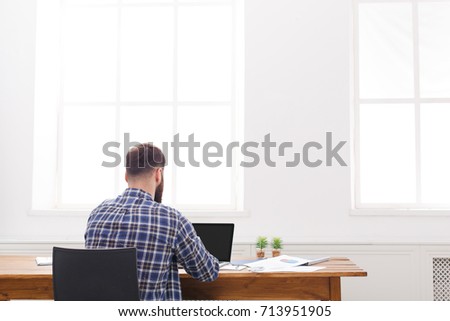 Successful male programmer background. Handsome manager in casual view from back with copy space on window. Relaxed man at work