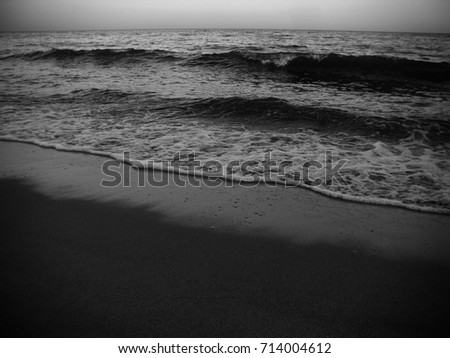 Waves and the sea shore in the evening. Monochrome photo. Background for web design