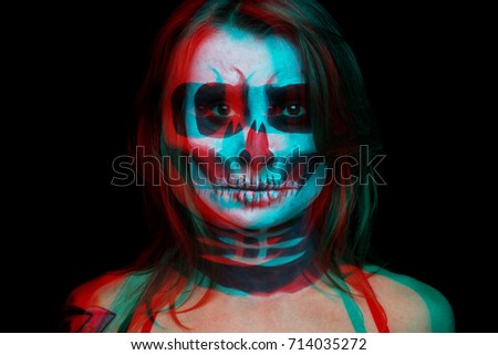 close up portrait of woman with Halloween skull make up over black background. the color shift effect is red.
