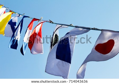 Different country flags weaving on a rope. Photo of a various country flags weaving on wind and blue sky on a background.