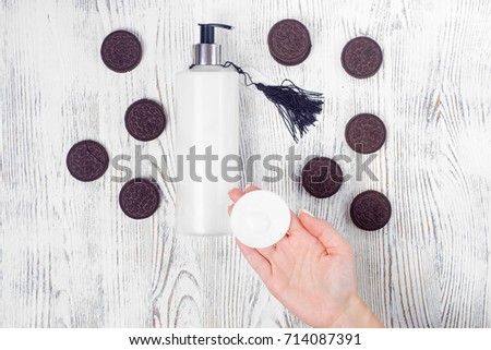 Female hand cream cotton pad cookie on a white wooden background