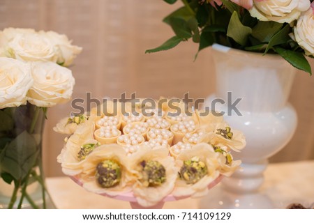 Horizontal picture of ornated table with bonbon with white chocolate and flowers for woman party