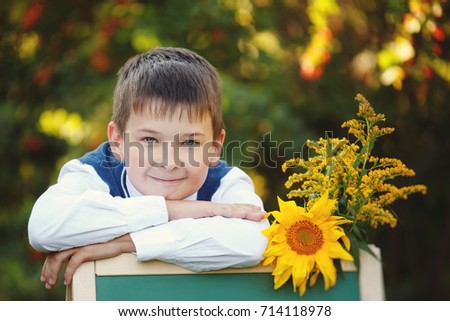 Cute little boy in a school uniform fall in the Park. Closeup portrait