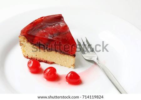 isolated on white served slice of fresh baked delicious cherry cheese cake with cherry topping