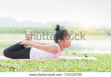 Happy cute girl playing gymnastic on outdoor park, exercise and healthy concept