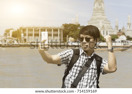 Men are taking photos of themselves on the banks of the Chao Phraya River.