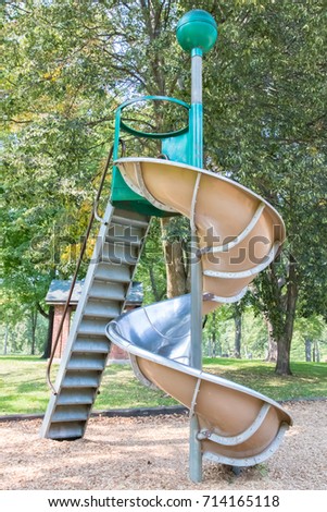 Steep spiral metal playground slide Royalty-Free Stock Photo #714165118