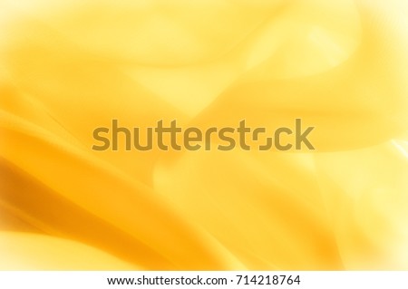 The photo is blurred. Texture, background, pattern. Yellow silk fabric. Abstract background of luxury Yellow fabric or liquid wave or wavy grunge texture. The whole background. Royalty-Free Stock Photo #714218764