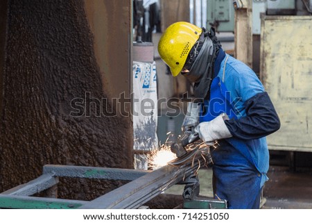 Man is polishing an automotive part. 