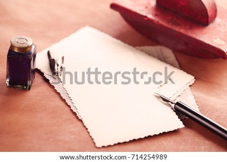 vintage red leather ink blotter  with retro post cards on leather table, shallow dof