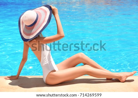 Beautiful young woman near swimming pool