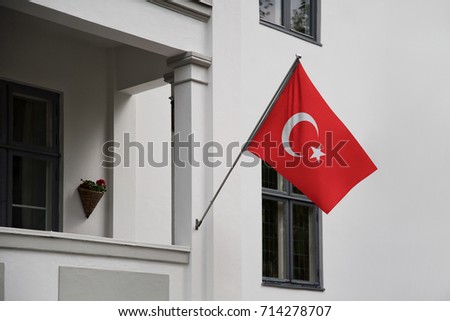 Turkey flag. Turkish flag displaying on a pole in front of the house. National flag of Turkey waving on a home hanging from a pole on a front door of a building.
