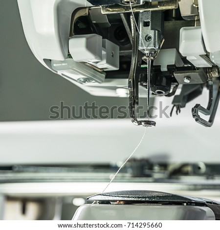 Embroidery machines part of embroidering area
needle and presser foot white thread pass through the hole