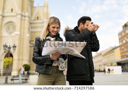 Young attractive happy couple enjoying city as tourists