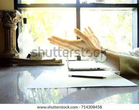 Businesses happen everywhere, just have inspiration. The picture of white laptop with Male hand on wooden table near the window at home office. selective focus