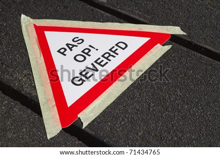 A triangular wet paint warning sign in Dutch