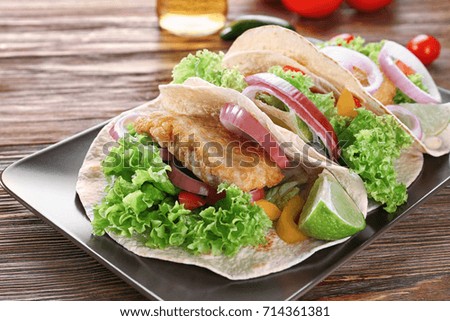Plate with delicious fish tacos on kitchen table