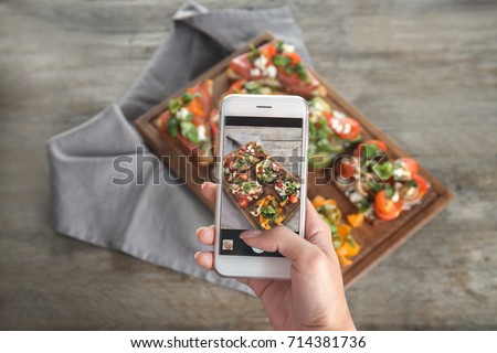 Female hand taking photo of food with mobile phone