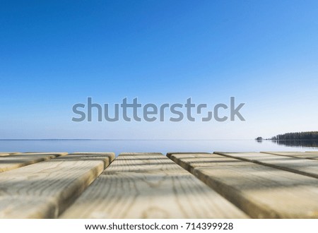 Wooden board empty table in front of blue sea & sky background. Perspective wood floor over sea and sky  beach & summer concepts.