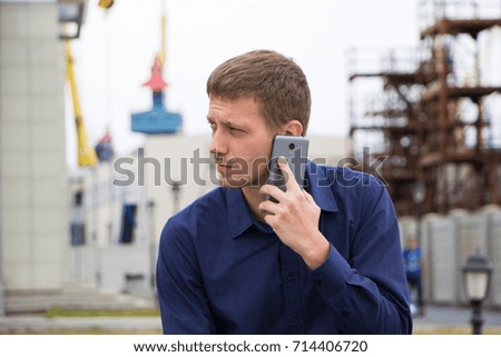 male engineer on building background speaks by phone