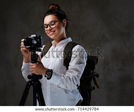 Traveler female taking pictures with a digital camera on a tripod.