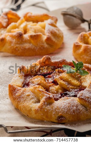 Homemade galette with plum and pears on rustic background. French cuisine - Breton galette 