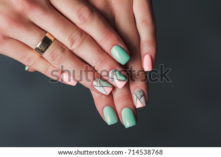 Geometry nail art design in pink and green colors on dark background