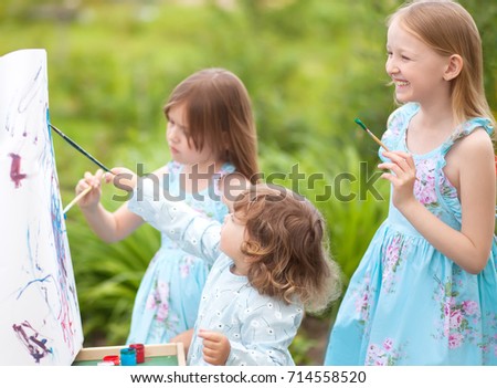 Sisters painting together in a beautiful garden, smiling and laughing