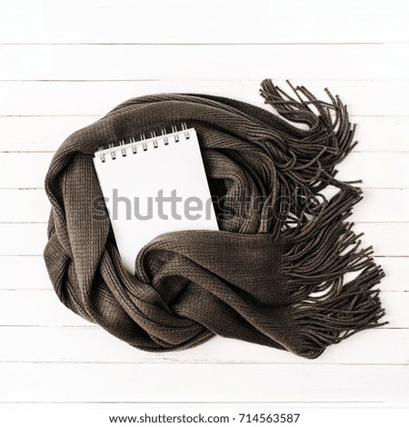 Empty card wrapped in scarf. Autumn or Winter concept.  Flat lay, top view