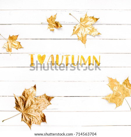 I Love Autumn. Golden maple leaves on a white wooden background. 