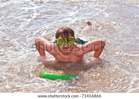 boy has fun with the surfboard at the beach