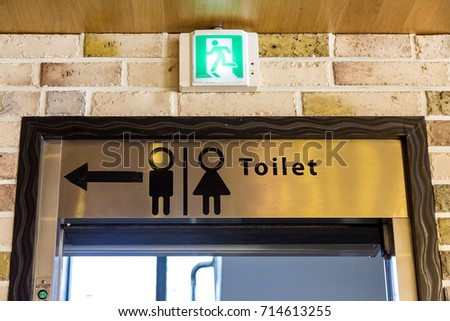 The sign of arrow point to toilet on the door