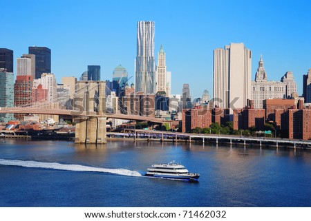 New York City Manhattan skyline with Brooklyn Bridge and skyscrapers over Hudson River in the morning after sunrise.