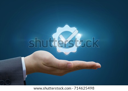 Hand shows the sign of the top service on the blue background . Royalty-Free Stock Photo #714625498