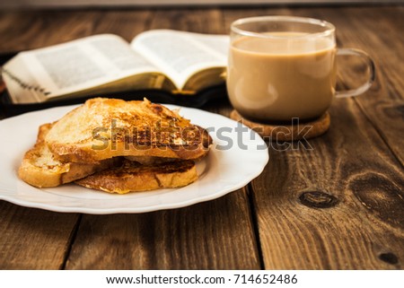 Bible and coffee French toasts cactus breakfast wooden background Royalty-Free Stock Photo #714652486