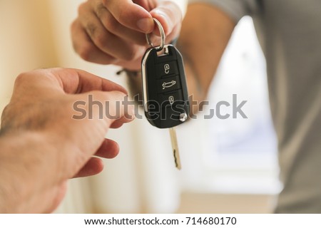 Hand of business man gives the car key Royalty-Free Stock Photo #714680170