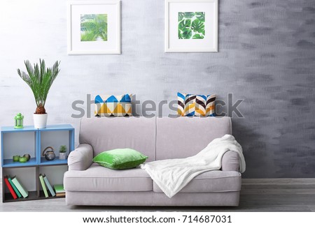 Modern living room design with framed pictures of tropical leaves and sago palm